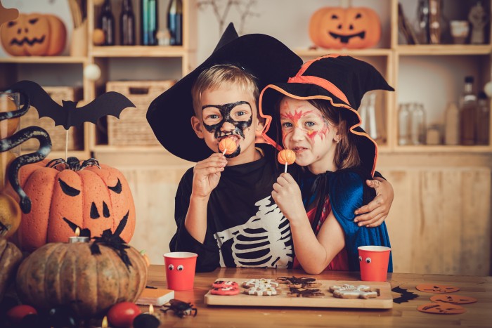 Hugging boy and girl enjoying sweets at Halloween party